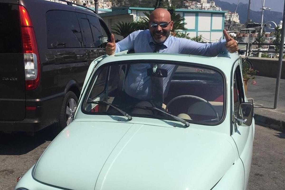 Un hombre levanta el pulgar mientras está sentado en un coche.
