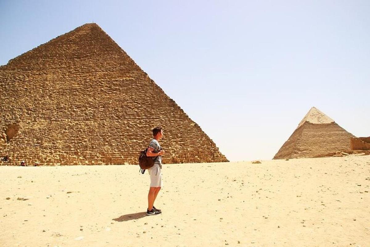 mies seisoo pyramidien edessä