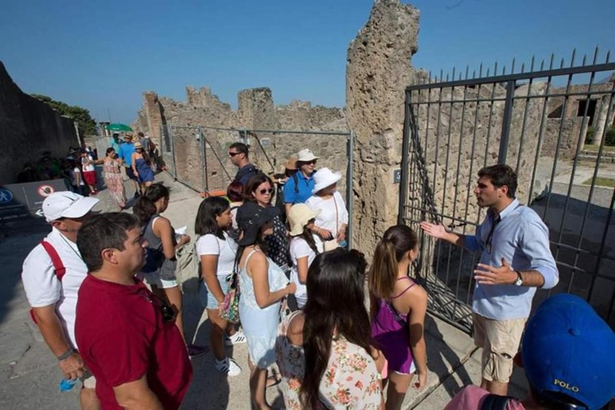 un gruppo di persone in piedi vicino a una recinzione
