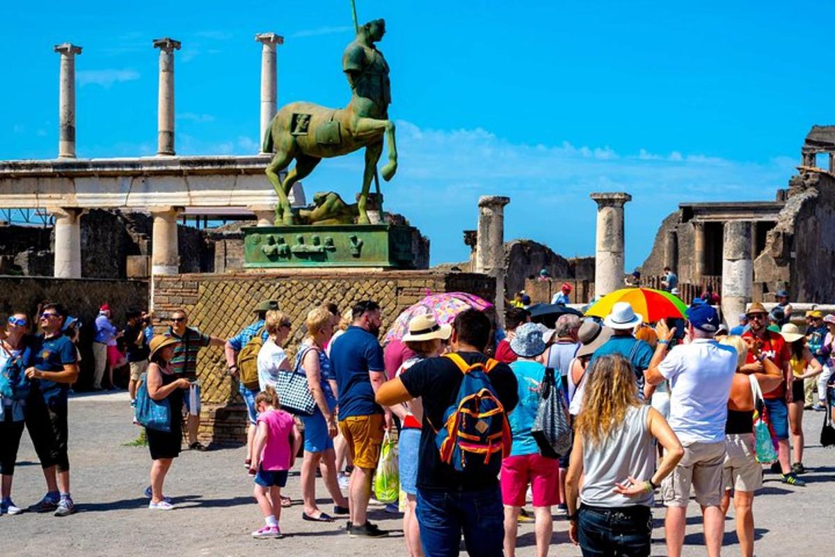 una folla di persone in piedi davanti a una statua
