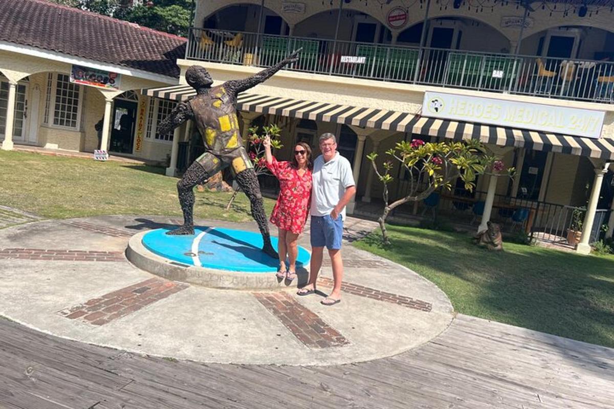 Un hombre y una mujer de pie junto a una estatua