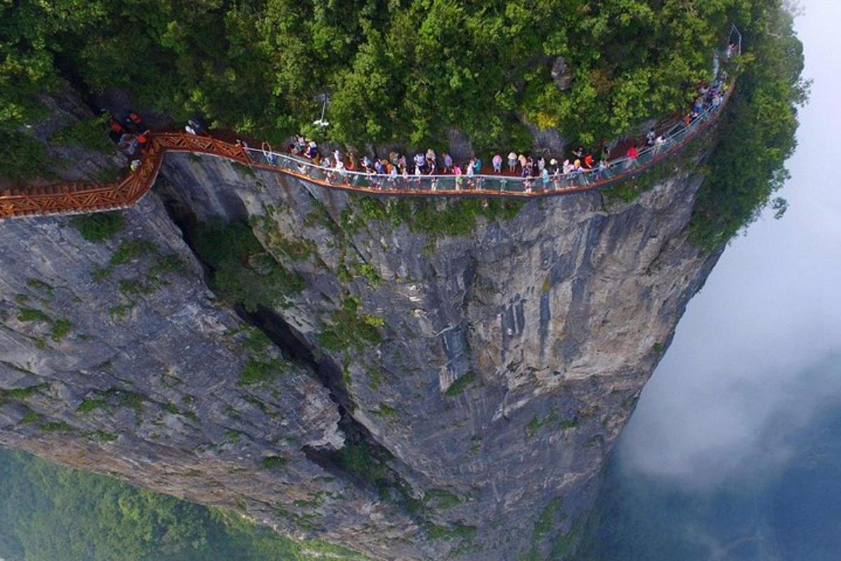 a group of people standing on the edge of a cliff