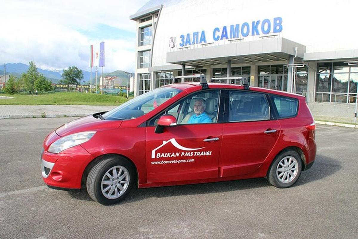 o mașină mică și roșie parcată în fața unei clădiri