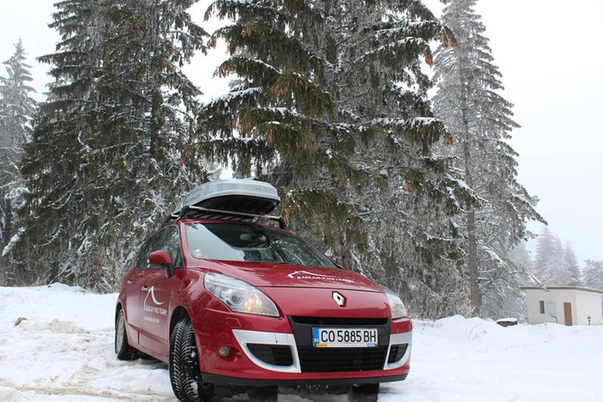 a red car is parked in the snow