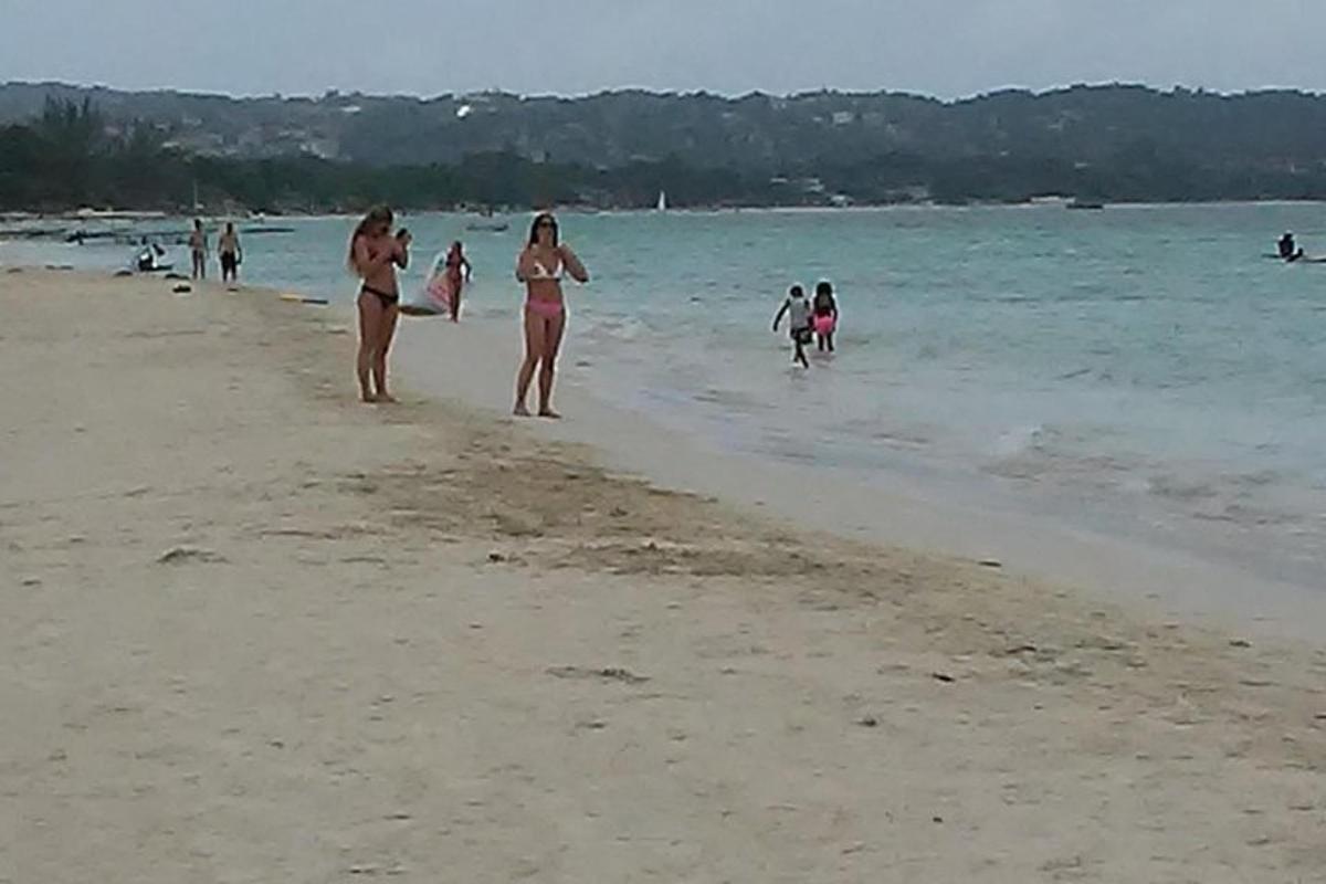 sekelompok orang berjalan di pantai