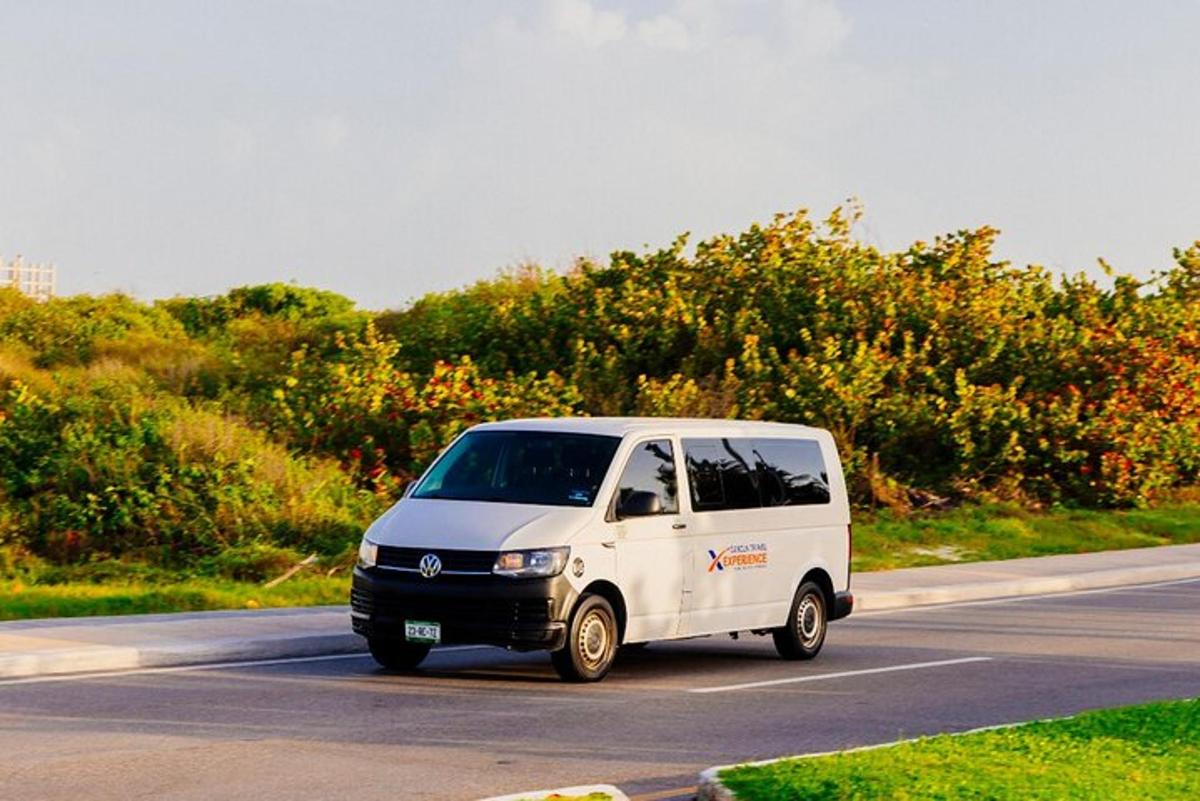 a small white van driving down a road