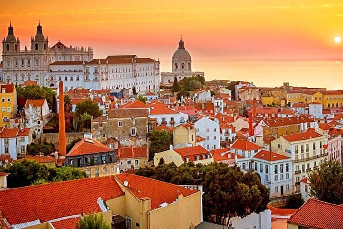 una vista di una città con i tetti rossi al tramonto