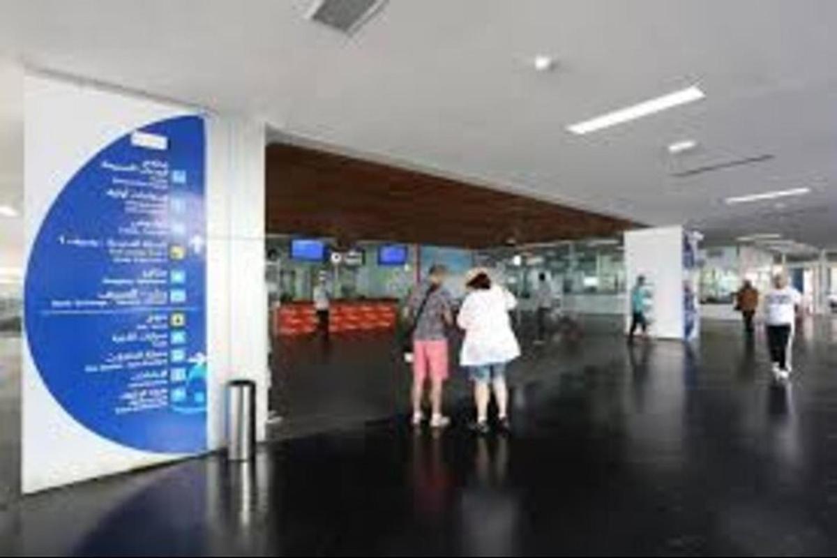 en gruppe mennesker som står i en flyplassterminal