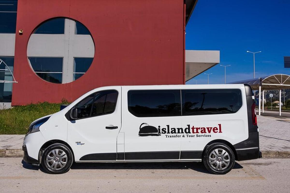hvítur sendibíll lagður fyrir framan byggingu