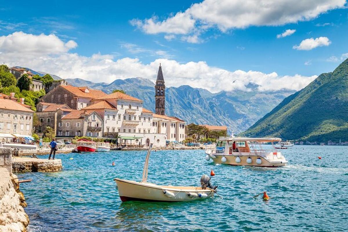 dvě lodě ve vodní ploše s budovami a horami