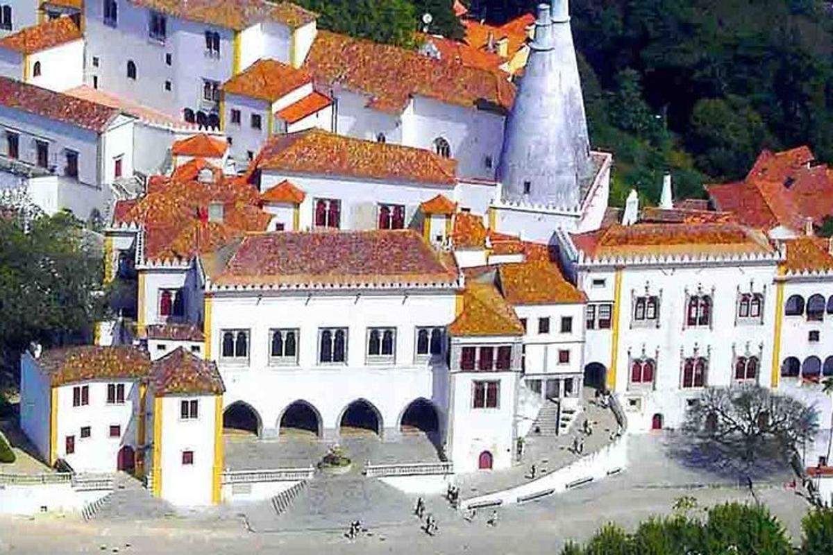 a large white building with red roofs and a church