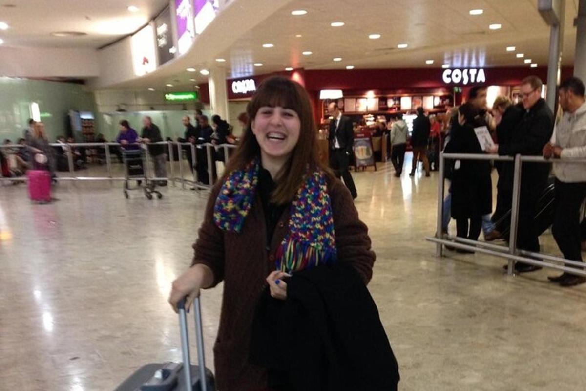 una donna in piedi in un aeroporto con i suoi bagagli