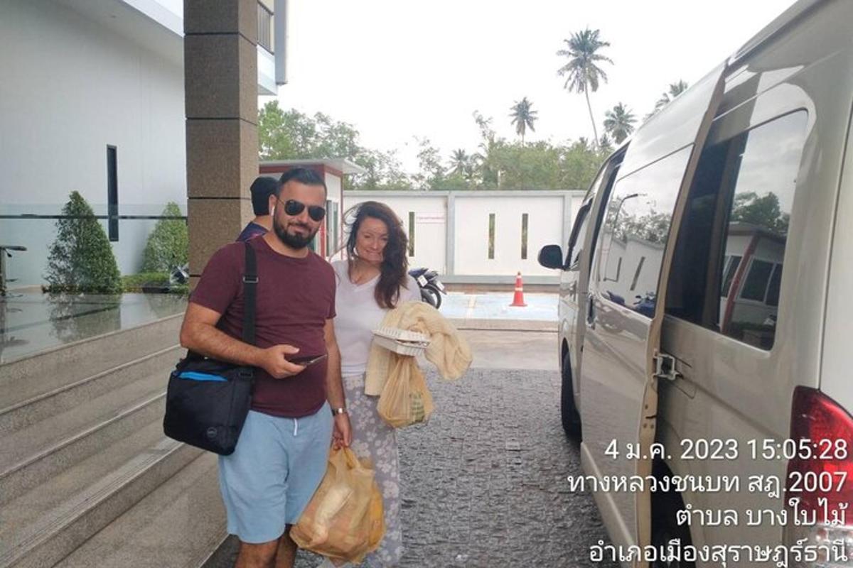 a man and a woman standing next to a van