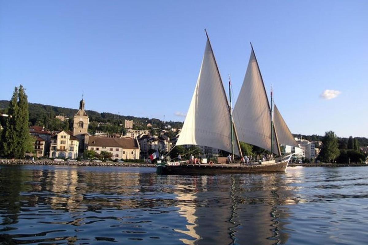 a boat with two sails in a body of water