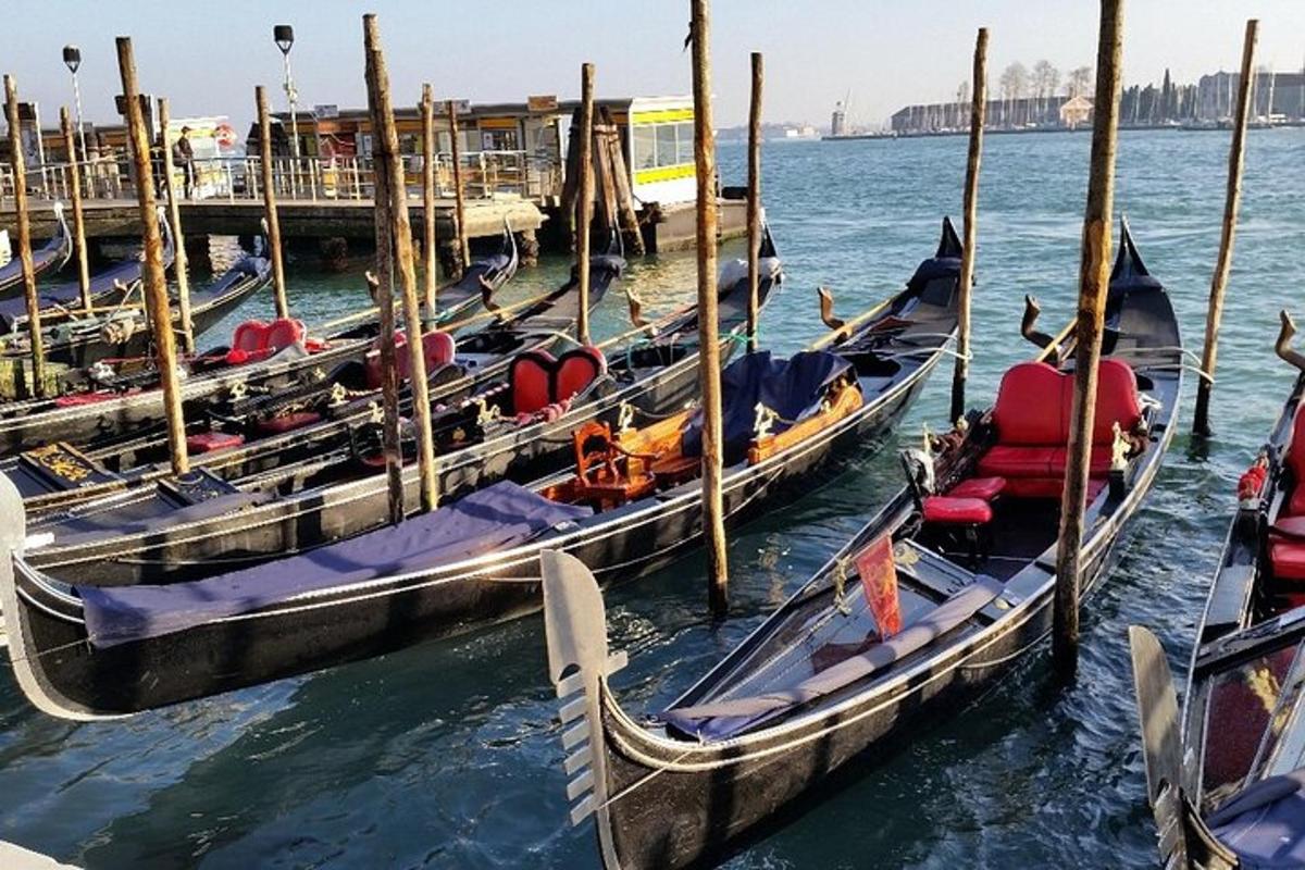 isang grupo ng mga gondola sa tubig malapit sa isang pier
