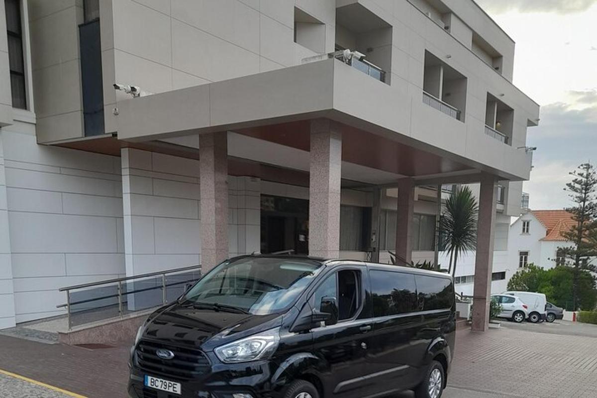 črn kombi parkiran pred stavbo