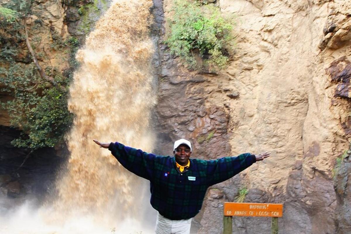 seorang lelaki berdiri di hadapan air terjun