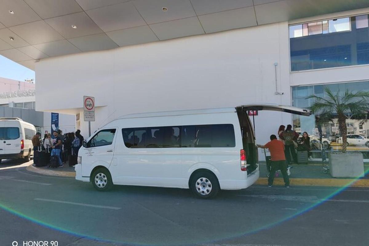 Una camioneta blanca estacionada en un estacionamiento con la puerta abierta