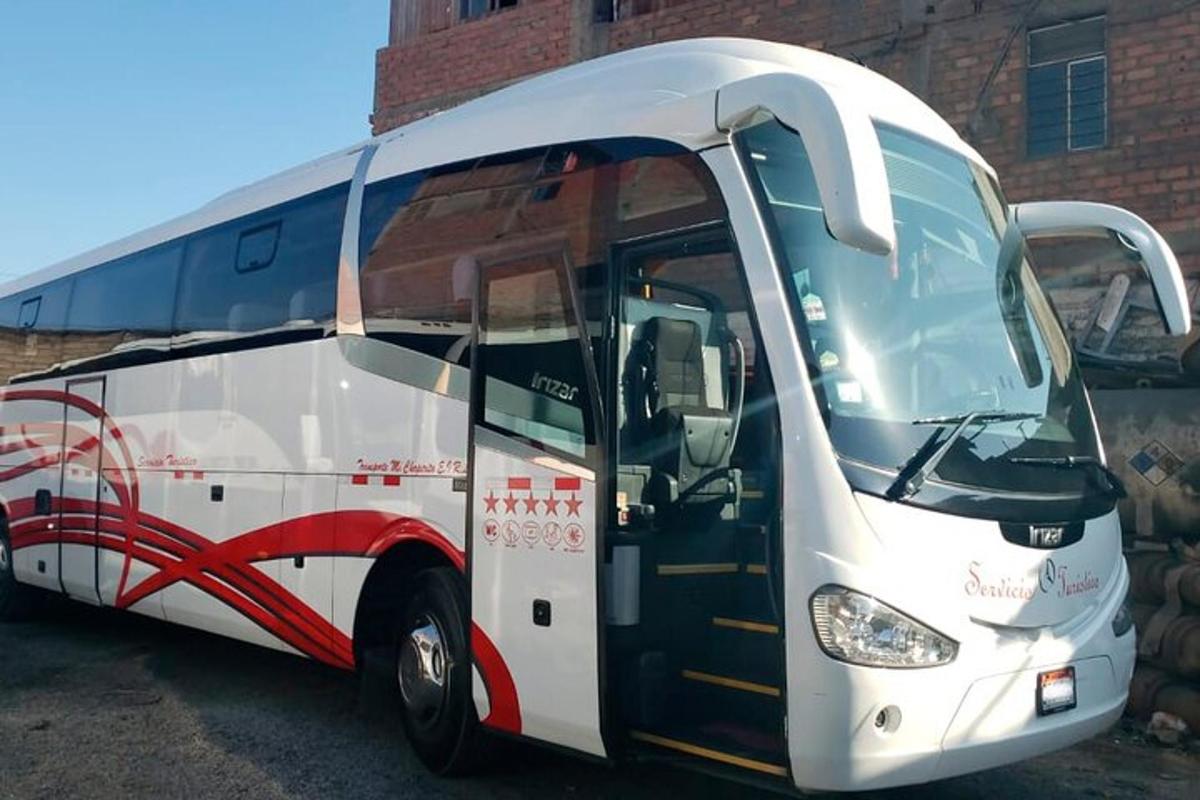 bílý autobus zaparkovaný před cihlovou budovou