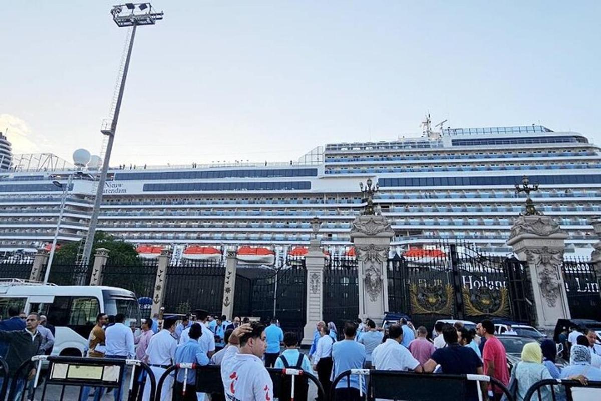 una folla di persone in piedi davanti a una nave da crociera