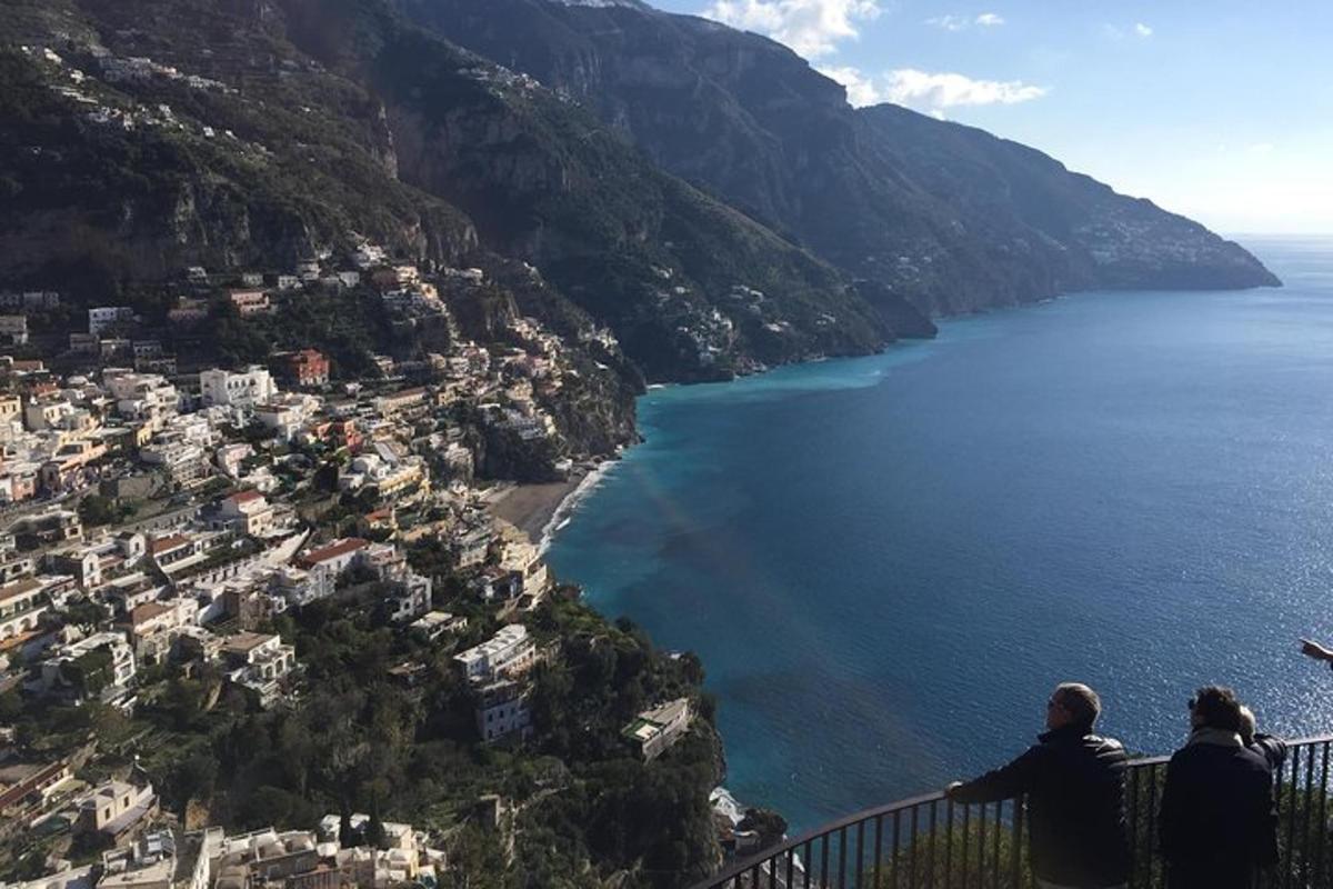 due persone sedute su una sporgenza che guardano l'oceano