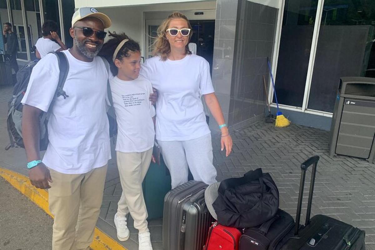 uma família posando para uma foto com sua bagagem