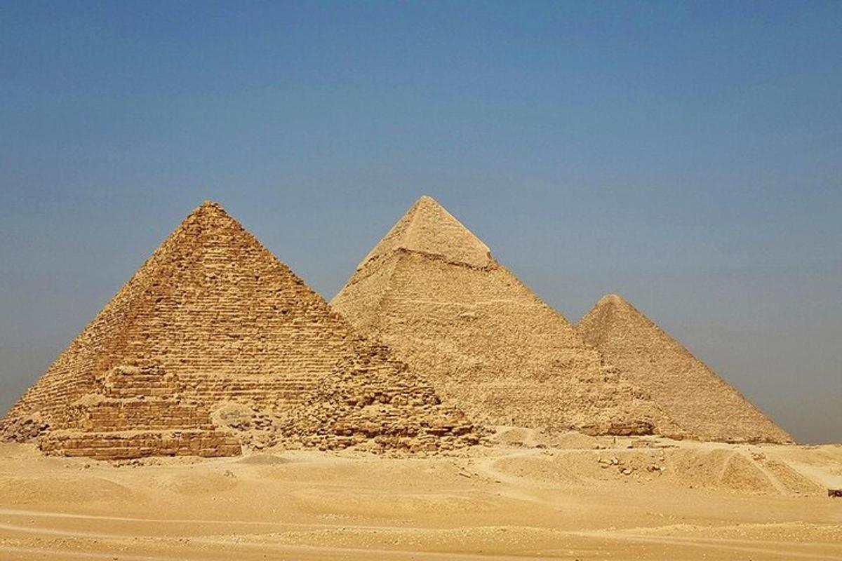 Skupina pyramid v poušti pod modrou oblohou