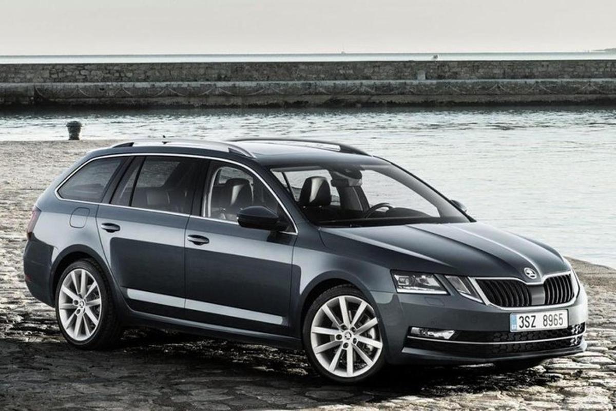 un'auto grigia parcheggiata su una spiaggia vicino all'acqua
