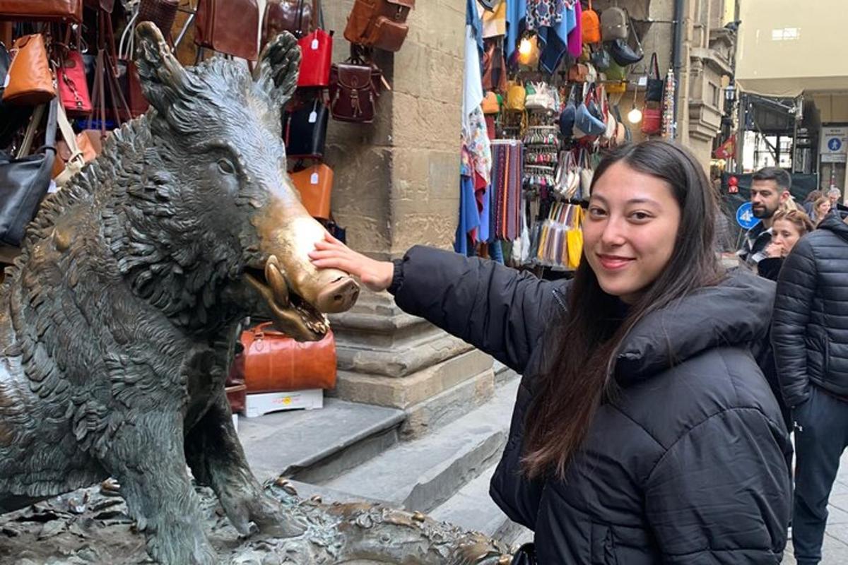 una donna in piedi accanto alla statua di un maiale