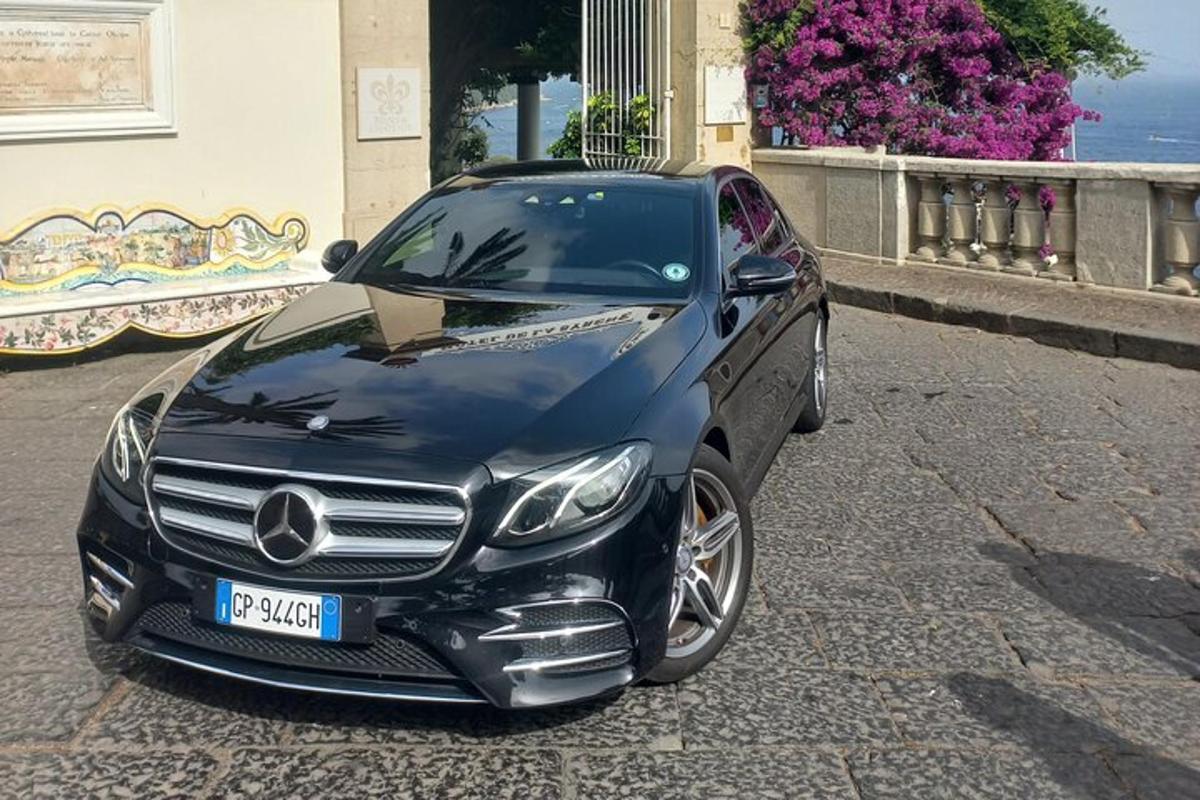 um carro preto estacionado na beira de uma rua