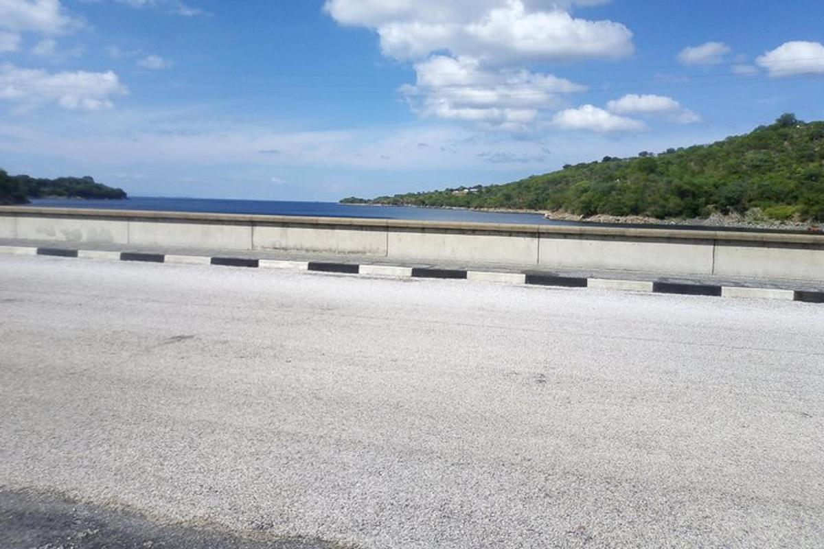 a bridge over a road next to a body of water