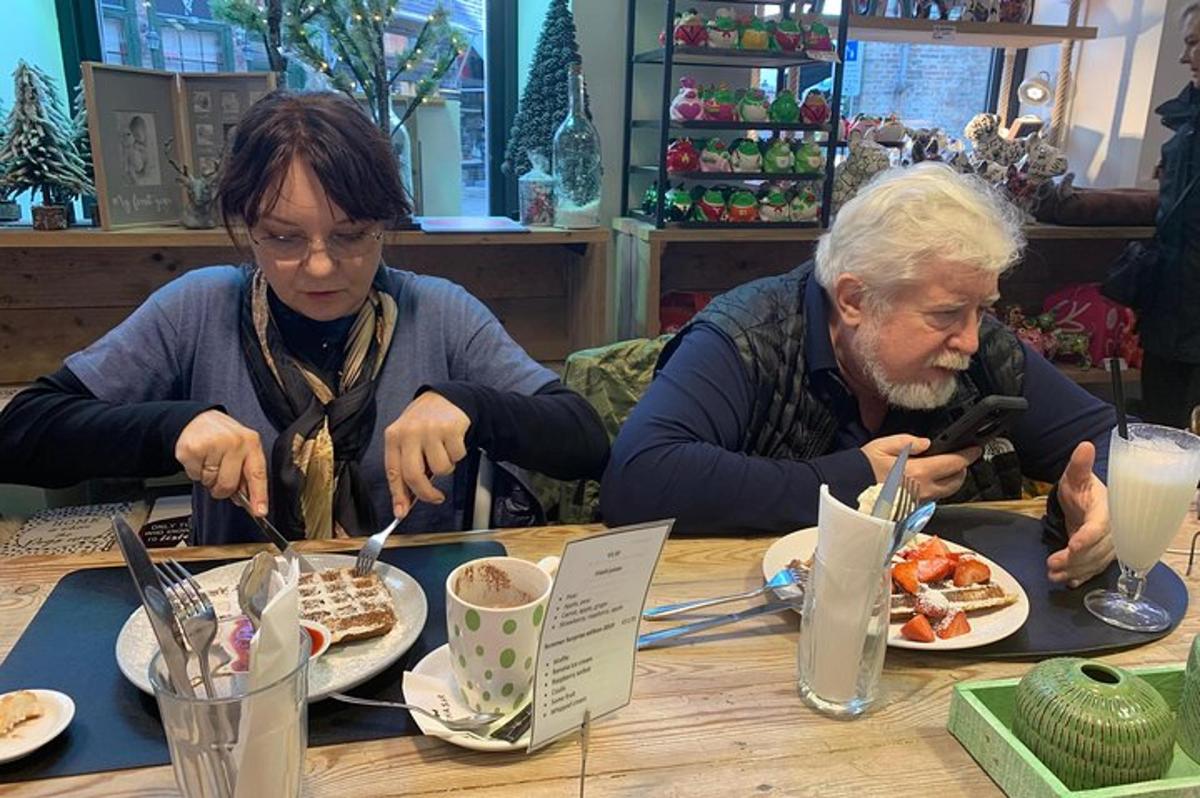 due persone sedute a un tavolo che mangiano cibo