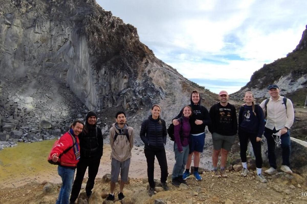 a group of people standing in front of a mountain