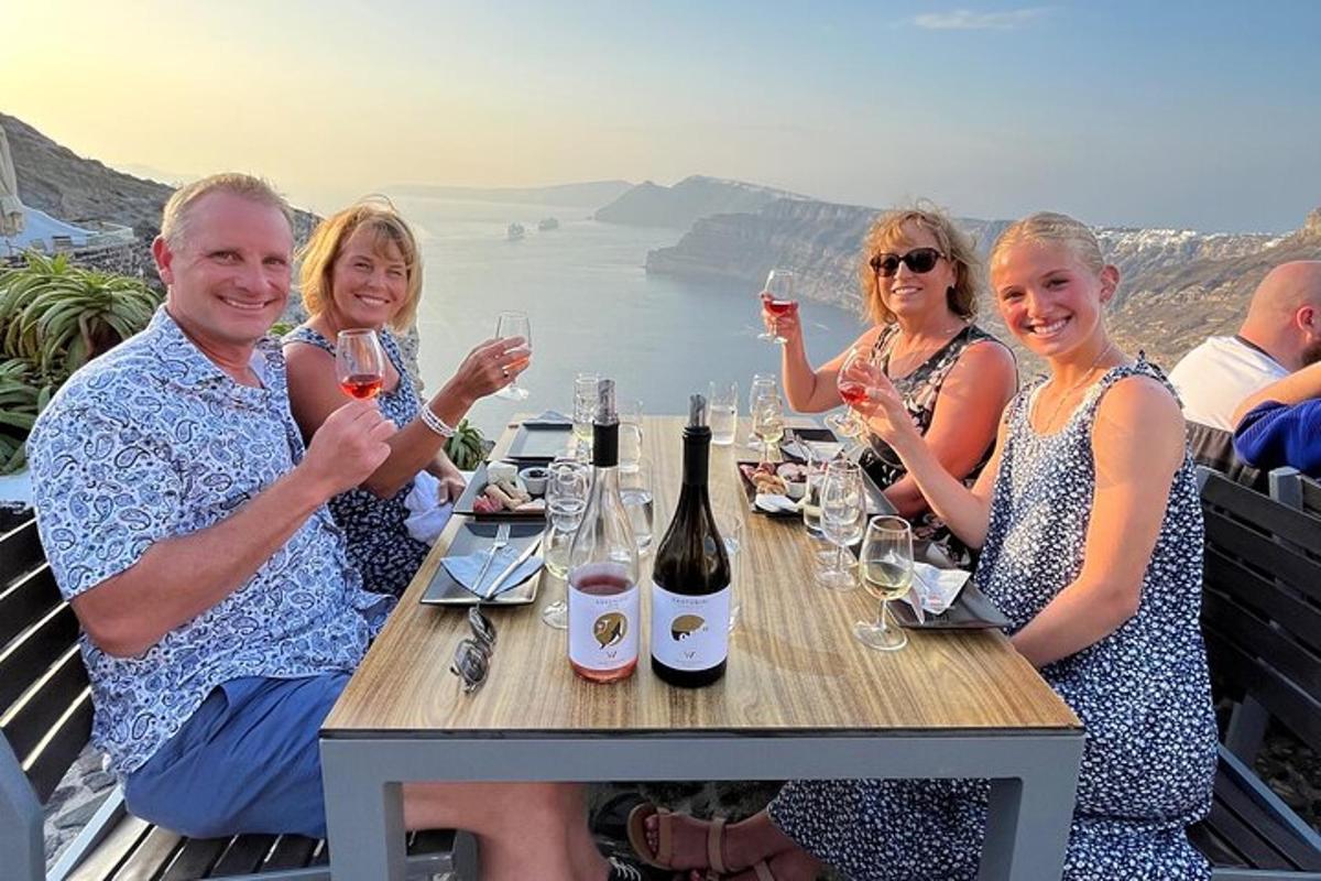 skupina ljudi, ki sedijo za mizo z vinskimi kozarci