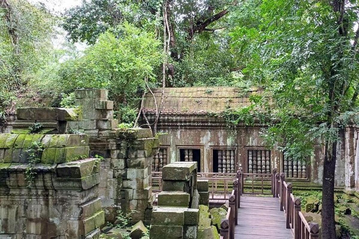 un vecchio edificio in pietra con una passerella in legno di fronte