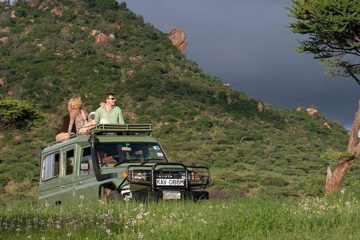 a man and woman sitting on top of a green van