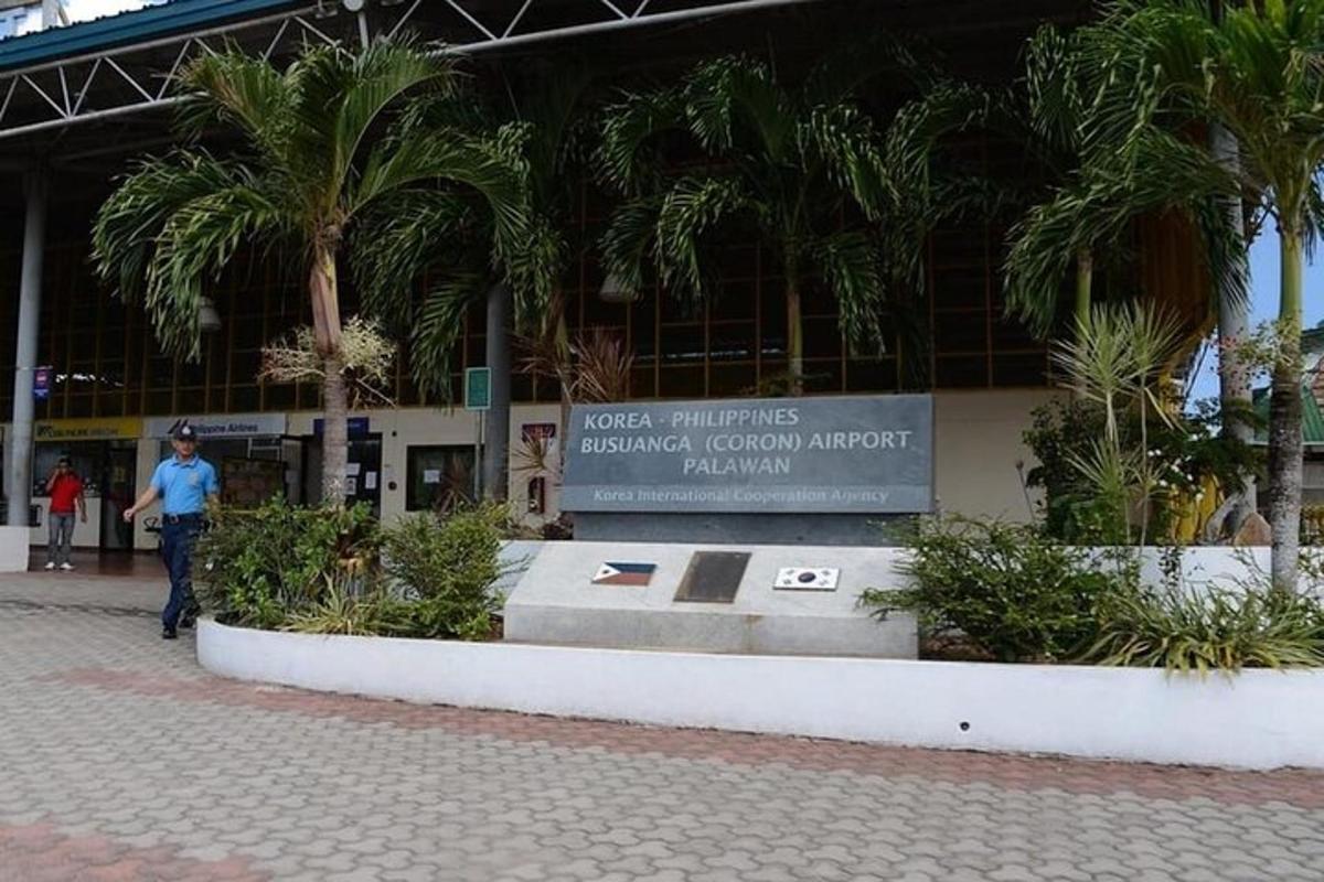 a man standing in front of a building with palm trees