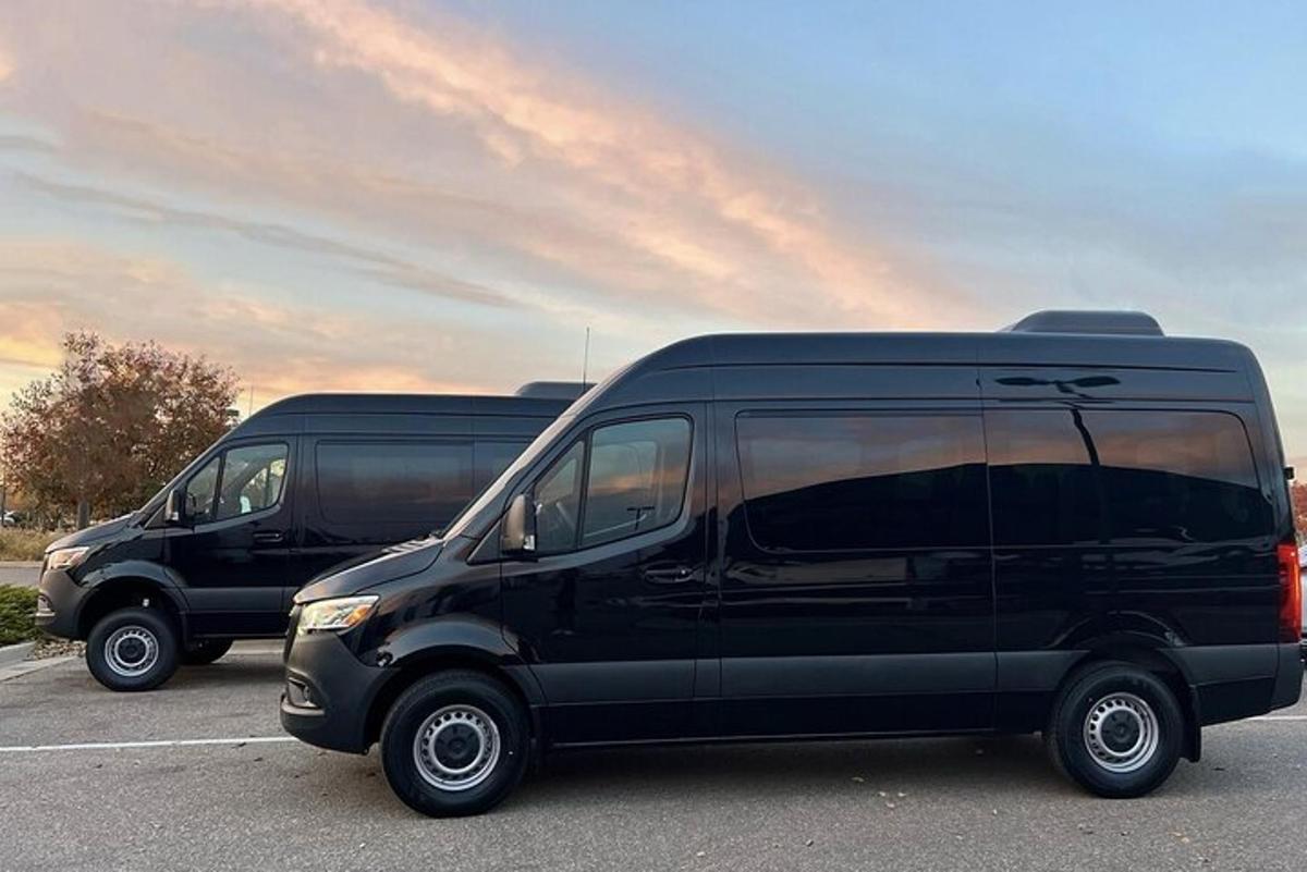 duas vans pretas estacionadas em um estacionamento