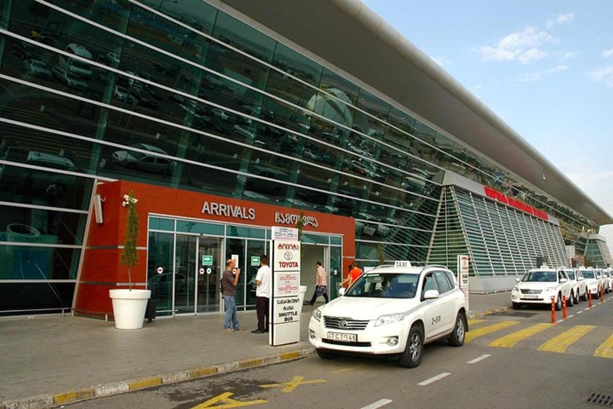un'auto bianca parcheggiata davanti a un grande edificio