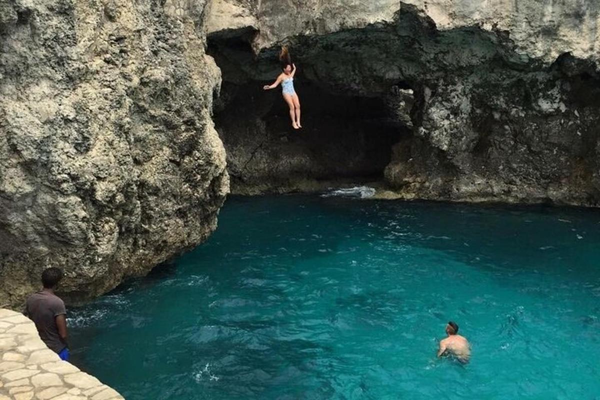 una donna che salta da una scogliera in un fiume