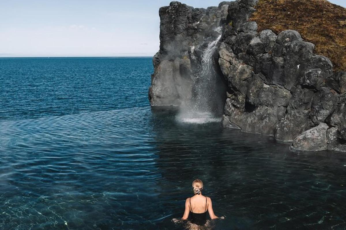 un hombre en el agua frente a una cascada