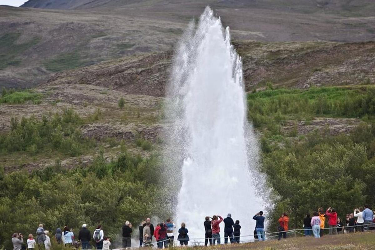 Un grupo de personas de pie frente a una cascada.