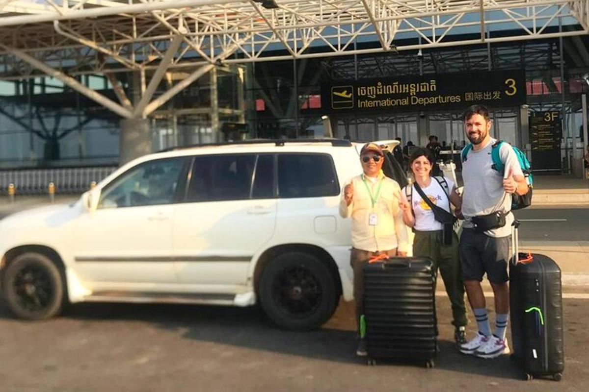 skupina lidí stojících před bílým autem