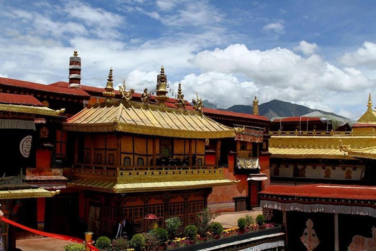 a building with a gold roof with mountains in the background