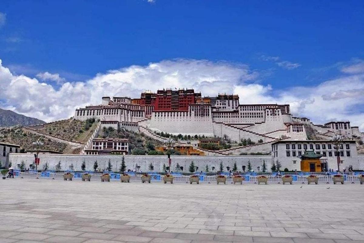a large building on top of a hill with chairs