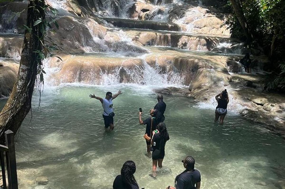 un gruppo di persone in piedi nell'acqua vicino a una cascata