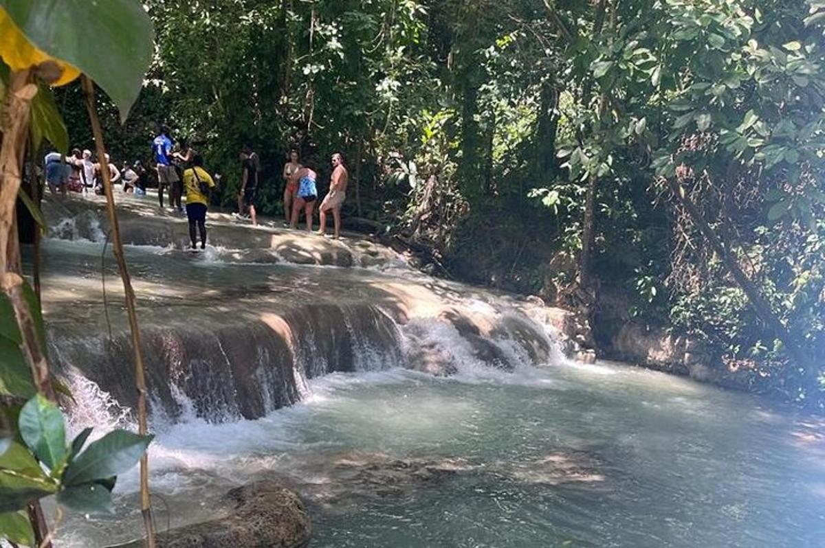 un gruppo di persone in piedi in cima a una cascata