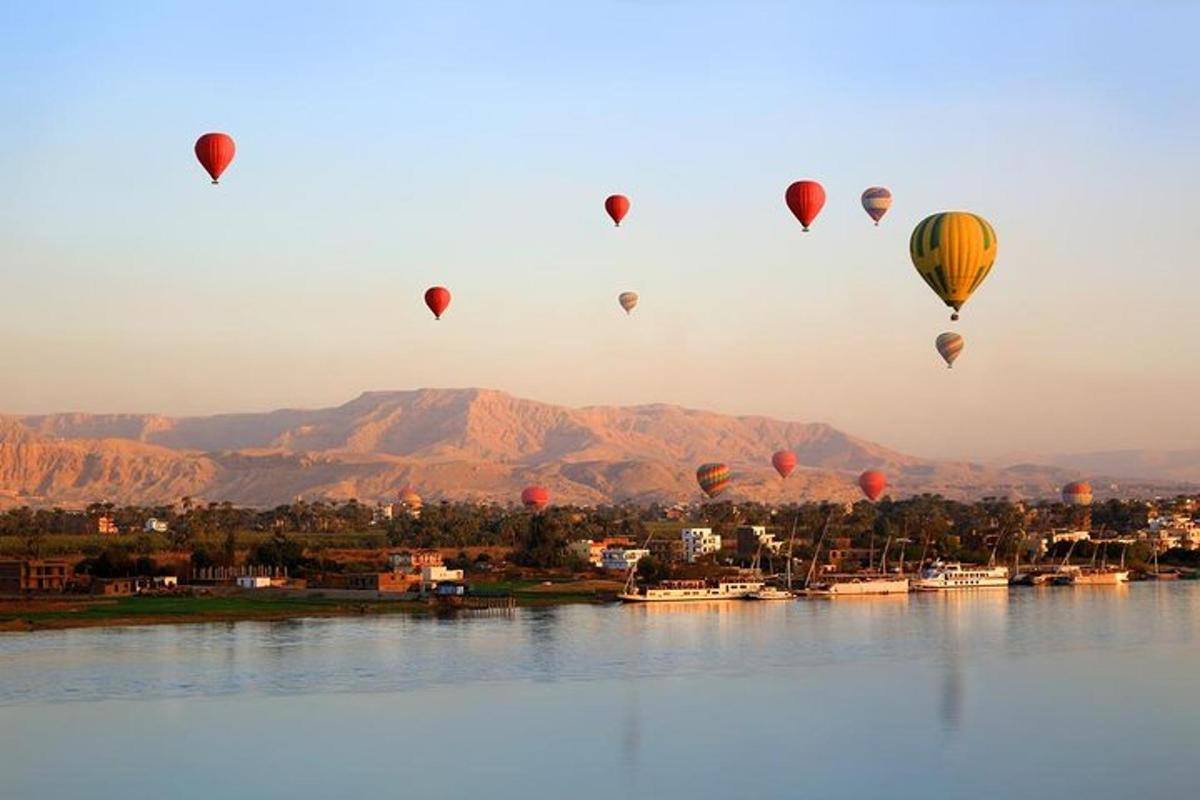 un grupo de globos aerostáticos volando sobre el agua