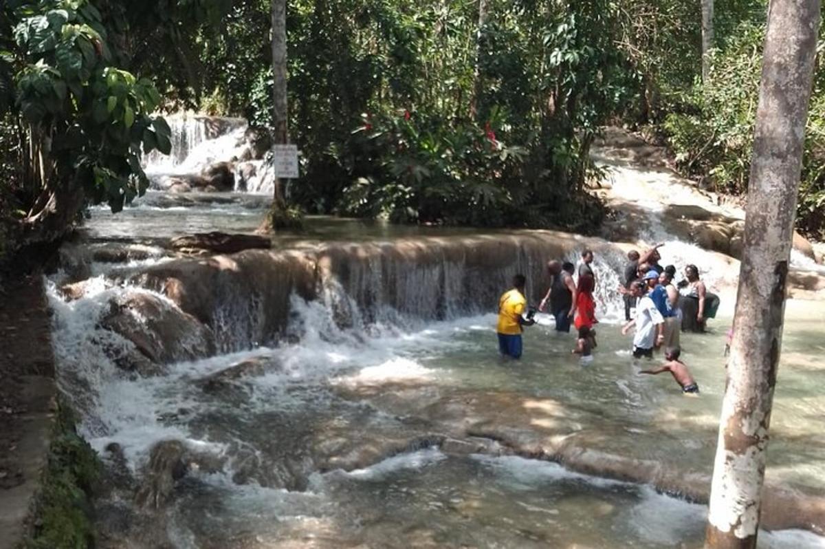 un gruppo di persone in piedi davanti a una cascata