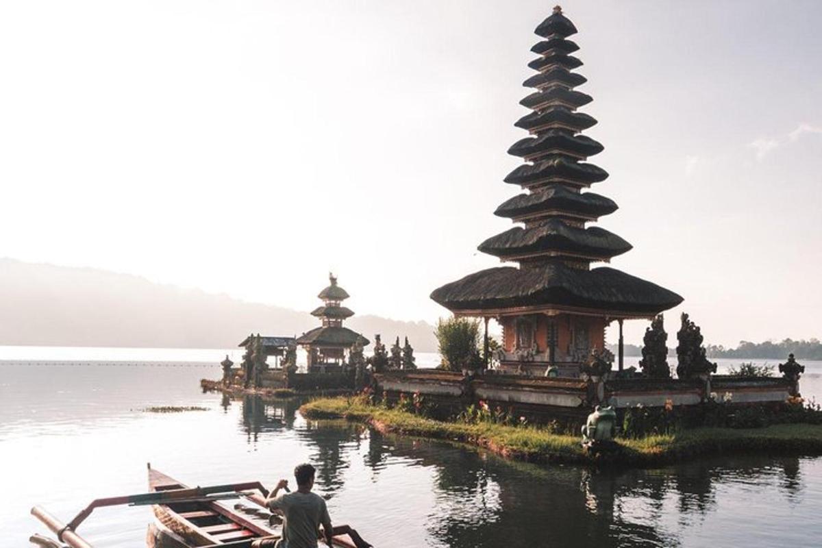 un gruppo di persone su una barca in acqua con una pagoda